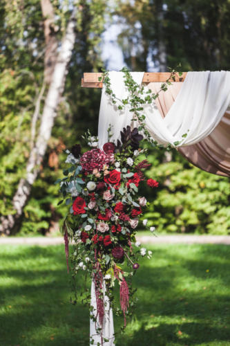 Wedding ceremony in rustic style decorated with different red fl