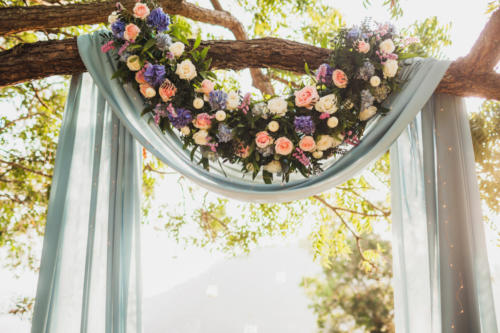 Sunset wedding ceremony, arch decorated with grey cloth hanging